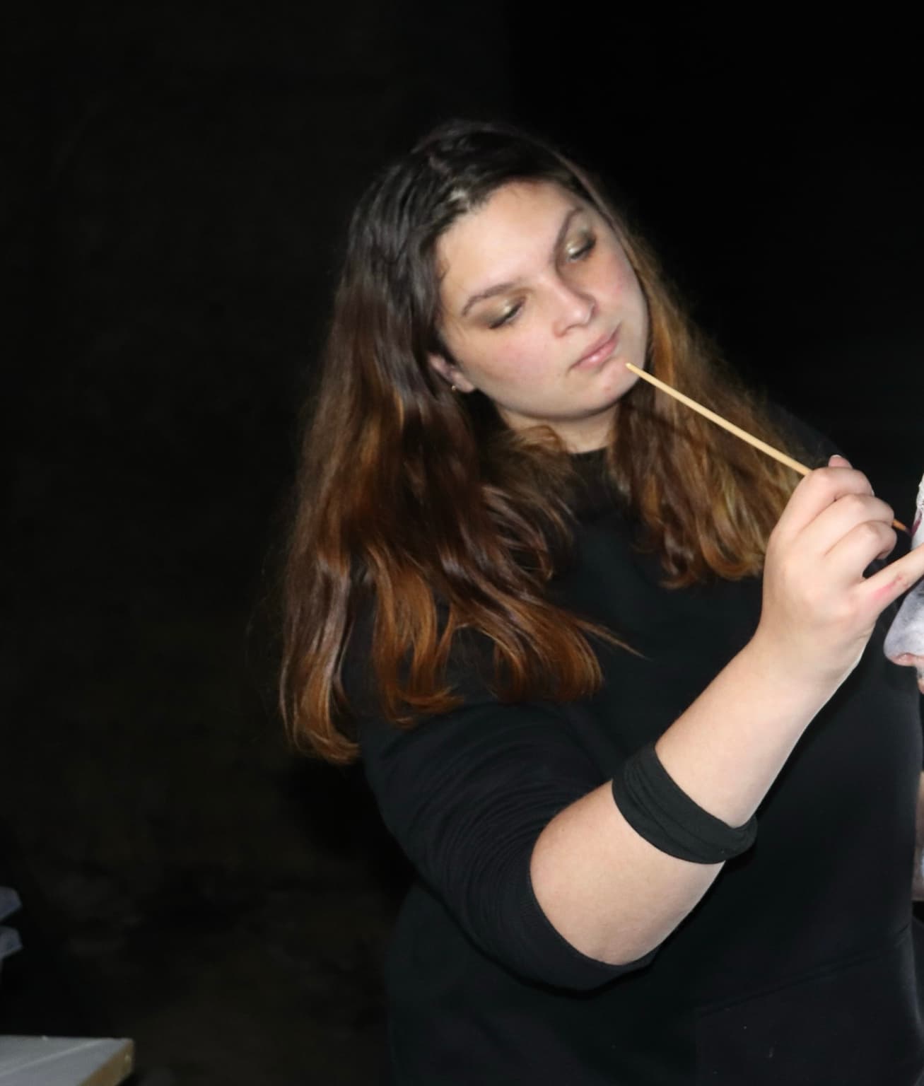 Héloïse travaille au pinceau sur un maquillage.